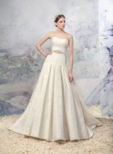 Style #1625L, jacquard a-line wedding gown with pleated skirt and beaded belt, available in ivory