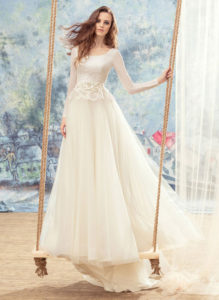 Style #1709L, tulle ball gown with lace open back, long sleeves and floral 3-D embroidery at the waist, available in ivory
