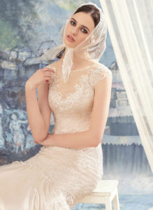 Style #1710L, beaded lace mermaid wedding dress with an illusion neckline, keyhole back and a tulle skirt, available in dark ivory (photo), ivory