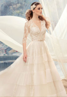 Style #1720L, beaded lace ball gown wedding dress with 3/4 length illusion sleeves and tiered skirt, available in ivory