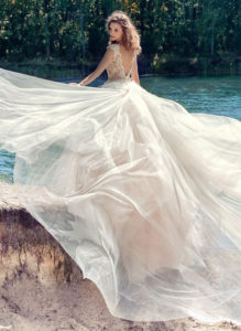 Style #1748L, illusion neckline ball gown wedding dress with open V-back and embroidered lace down the tulle skirt; comes with the detachable long train, available in nude-ivory (photo), white