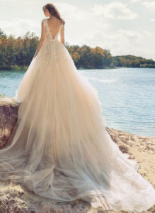 Style #1748L, illusion neckline ball gown wedding dress with open V-back and embroidered lace down the tulle skirt; comes with the detachable long train, available in nude-ivory (photo), white