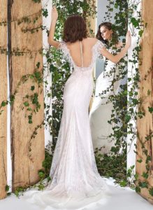 Style #1808L, lace off-the-shoulder wedding dress with feathers at the illusion neckline, available in light pink