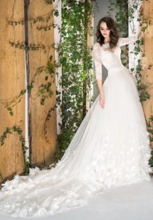 Style #1812Pr, three-quartered sleeve ball gown wedding dress, designed with the illusion neckline, 3-D floral decor, and lace scalloped hem, available in ivory