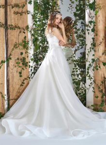 Style #1820L, sleeveless a-line wedding gown features feathers and beading embroidered lace top, a figure-cinching wide waistband with tulle skirt, available in ivory