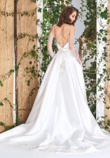 Style #1821L, lace embroidered a-line wedding gown with deep plunging neckline features crisscross spaghetti straps over the low back and satin skirt with pockets, available in ivory