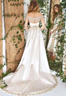 Style #1831L, high low a-line wedding dress, designed with short sleeves, illusion neckline and back, pockets, and lace decor, available in white, cream and ivory