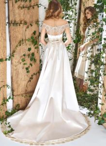 Style #1831L, high low a-line wedding dress, designed with short sleeves, illusion neckline and back, pockets, and lace decor, available in white, cream and ivory