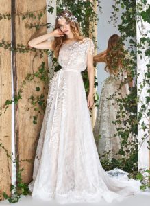 Style #1839L, lace a-line wedding dress, designed with illusion neckline and back, short sleeves, and floral decor, available in ivory and ivory-gold