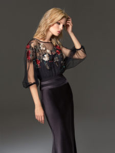 Style #334, fit-and-flare evening gown features flower embroidered illusion top with dolman three-quarter length sleeves, available in black