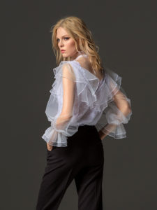 Style #338-3, high collared lace blouse with sheer bishop sleeves and ruffled details, available in white. Style #338-4, mid-rise skinny trousers, available in black, ivory, scarlet, dark blue, blue, pink-ivory, green, grey