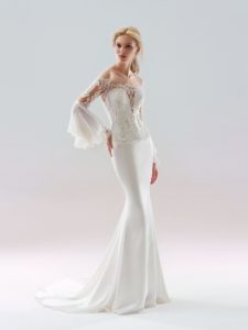 Style #18/1902L, bell sleeve fit-and-flare wedding dress with an illusion neckline on the embellished lace bodice, available in ivory