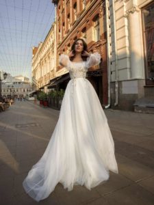 A-line wedding gown with an off-the-shoulder neckline, bishop sleeves, and floral appliqué