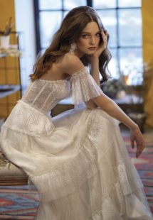 Style #2020, A-line wedding dress with ruffled skirt and off-the-shoulder bell sleeves, available in ivory