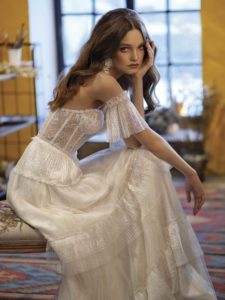 A-line wedding dress with ruffled skirt and off-the-shoulder bell sleeves