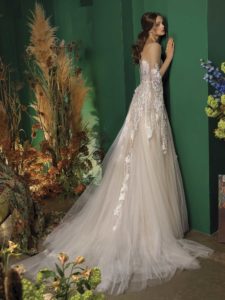 A-line wedding dress with deep V neckline, illusion panel on the chest, ruched fabric, and floral appliqué
