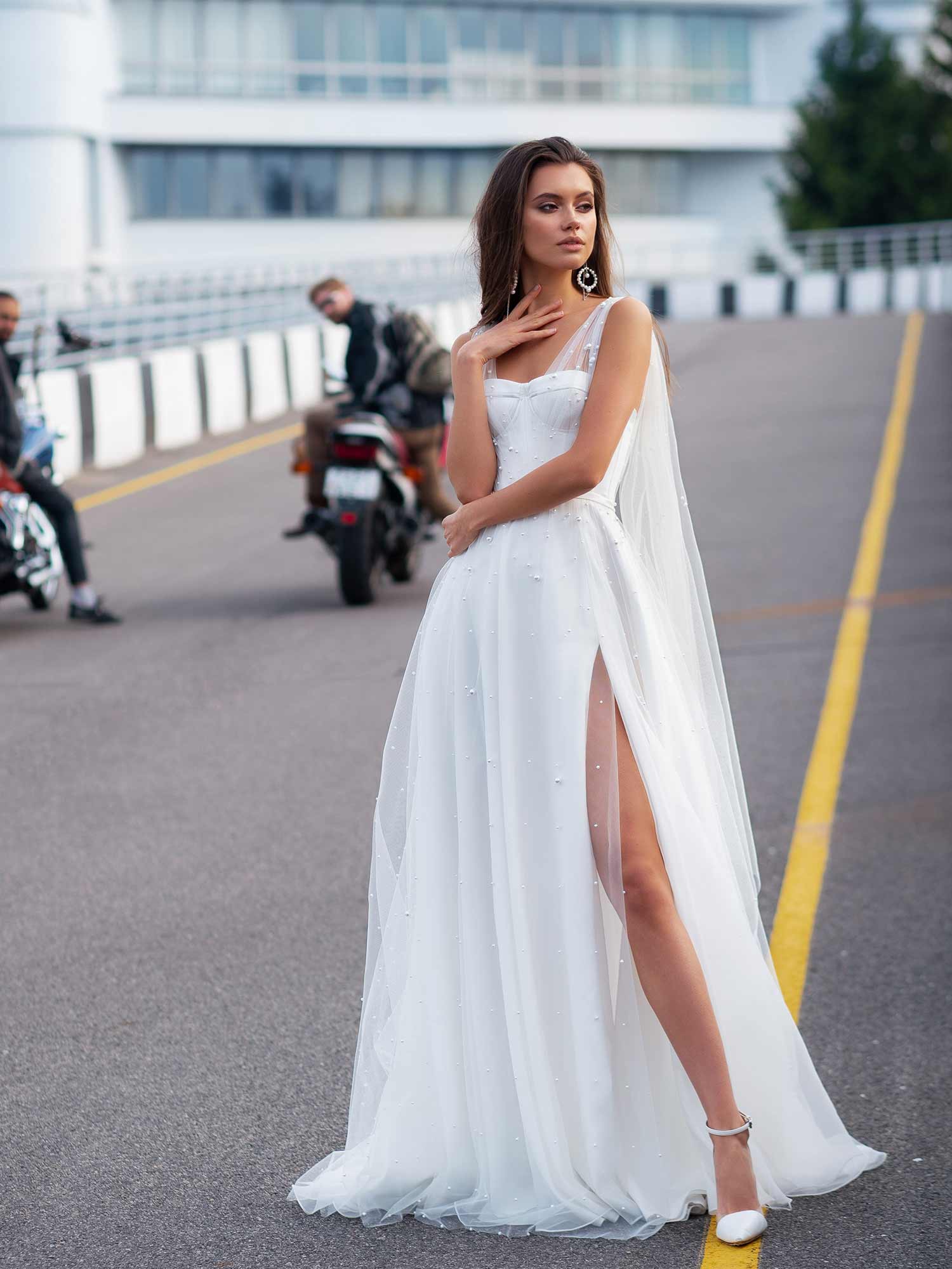 Style #12064, bridal gown with pearl embellishments and cape sleeves, available in ivory