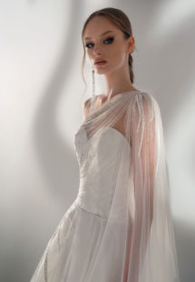 Style #2101, A-line wedding dress with one-shoulder cape sleeve, available in ivory