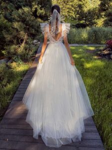 White glitter tulle A-line wedding dress with ruffled cap sleeves and open back