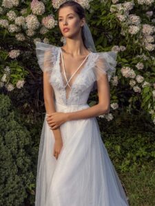 White glitter tulle A-line wedding dress with ruffled cap sleeves and open back
