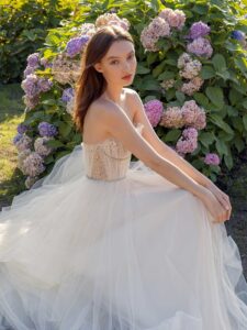 Strapless A-line wedding dress with frilled tulle neckline and sequinned bodice; available in ivory-nude, ivory