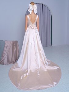 Style #2224L, Atlas A-line wedding dress with a plunging neckline, open back and side pockets, available in gold, white
