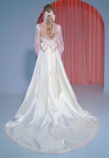 Style #2211L, long-sleeve A-line wedding gown with atlas skirt, lace high-neck top and oversized bow decor, available in ivory