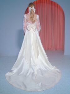 Long-sleeve A-line wedding gown with atlas skirt, lace high-neck top and oversized bow decor