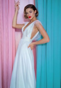 Style #2212L, chiffon sheath wedding gown with embroidered plunging V-neckline and open back, available in ivory