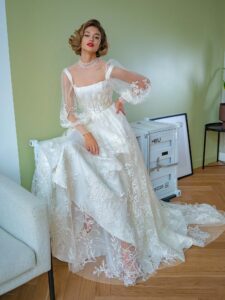 Tulle overlay dress with a high neck, long bishop sleeves and floral lace embroidery; comes with a satin inner dress
