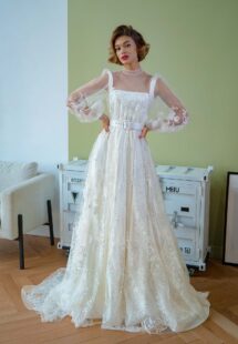 Style #2209L, tulle overlay dress with a high neck, long bishop sleeves and floral lace embroidery; comes with a satin inner dress, available in ivory