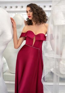 Style #649, satin sheath evening gown with off the shoulder sleeves and beaded belt; available in burgundy, ivory, green, red