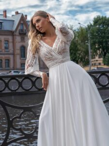 Long sleeve wedding dress with a flowy skirt; available in ivory-nude, ivory