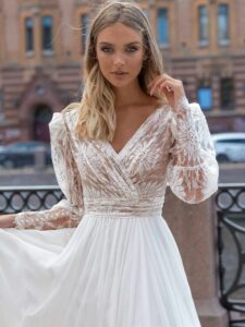 Long sleeve wedding dress with a flowy skirt; available in ivory-nude, ivory