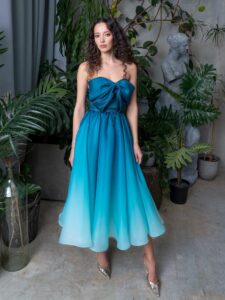 Style #731a, A-line tea-length organza ombre dress with a bow accent; available in midi or maxi length; in emerald, lavender