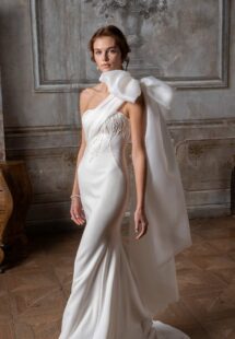 Style #2307L, one-shoulder fitted wedding dress with beading and oversized bow strap; available in ivory