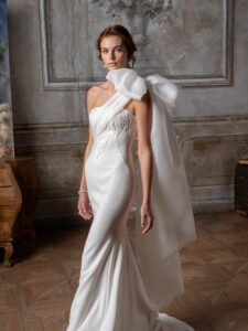 One-shoulder fitted wedding dress with beading and oversized bow strap
