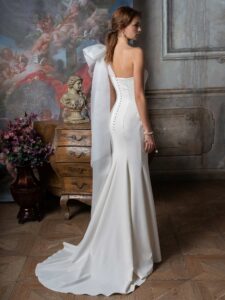 One-shoulder fitted wedding dress with beading and oversized bow strap