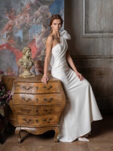 One-shoulder fitted wedding dress with beading and oversized bow strap