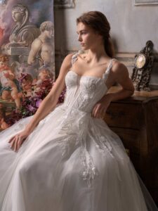 A-line wedding dress with thick straps, plunging bustier-style bodice and floral applique