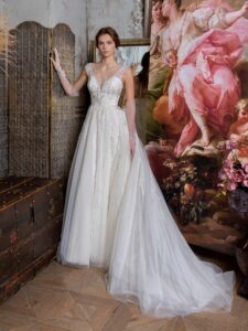 Ballgown wedding dress with an illusion V-neckline and beaded lace embroidery; available in cream