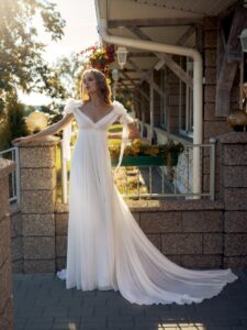 High-waisted wedding dress with an off-the-shoulder neckline and floral straps
