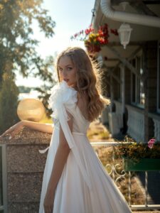 High-waisted wedding dress with an off-the-shoulder neckline and floral straps