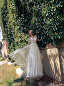 Lace A-line wedding dress with illusion neckline, flowers and butterfly decor