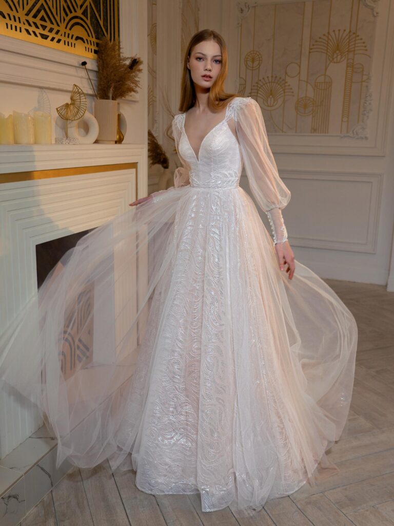 Style #2406L, sequinned A-line wedding dress with detachable long-sleeved overlay blouse; available in peach, ivory