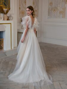 High-low A-line wedding dress with feathers and beads; available in cream
