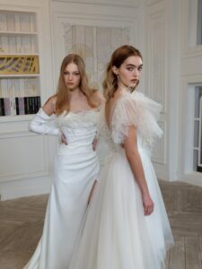 High-low A-line wedding dress with feathers and beads; Draped fitted wedding gown with long sleeves and feather decor