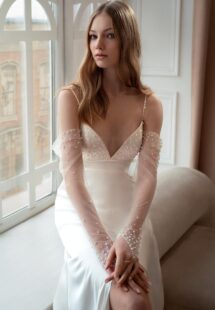 Style #2413L, Atlas sheath wedding gown with long off-the-shoulder sleeves; available in ivory-peach