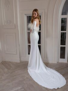 Draped fitted wedding gown with long sleeves and feather decor