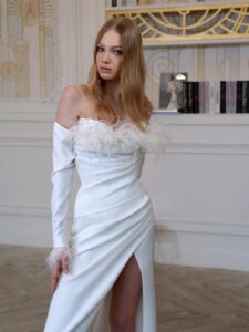 Draped fitted wedding gown with long sleeves and feather decor